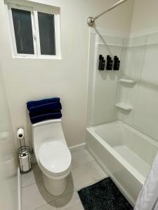 e bagno bianco con servizi igienici e vasca. di Sunset Dream Cottage a Los Angeles