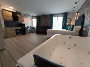 uma grande banheira branca numa sala de estar em Airen Suites em Chinchón