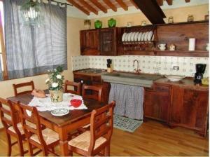 a kitchen with a wooden table with chairs and a sink at Nettes Appartement in Mignana mit gemeinsamem Pool und Panoramablick in Vinci
