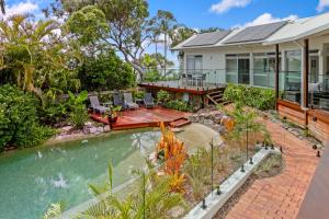 an aerial view of a house with a swimming pool and a patio at A Tropical Family Oasis in Sunshine Beach in Sunshine Beach