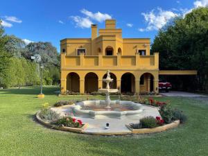 un gran edificio amarillo con una fuente en el patio en El Castillo en Campana