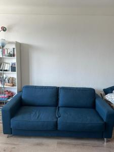 a blue couch sitting in a living room at En plein cœur de Paris Saint-Lazare Hausman / Paris center Hausman Opera in Paris