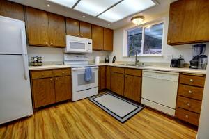 uma cozinha com electrodomésticos brancos e armários de madeira em Green Valley Getaway - 2br Family Friendly Home em Mendenhaven