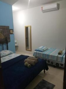 a bedroom with two twin beds and a mirror at Pousada Tulum in Barra Grande