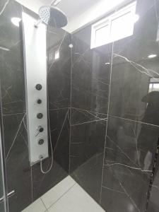 baño con ducha de azulejos negros en Suite de lujo 201, en Guatapé