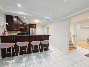una cocina con barra con taburetes. en Beautiful Room at Yonge and Sheppard and North York Centre, en Toronto