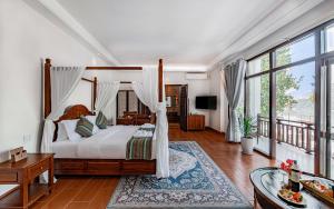 a bedroom with a canopy bed and a balcony at Relaxful Hotel泊岸酒店 in Luang Prabang