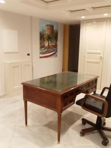 a desk with a glass top in a room with a chair at Federico 70 Acquamarina in Palermo +2 photos