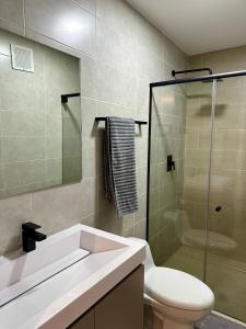 a bathroom with a toilet and a glass shower at Apartamento en Panama in Panama City