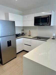 a kitchen with white cabinets and a stainless steel refrigerator at Apartamento en Panama in Panama City