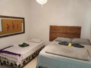 a bedroom with two beds and a painting on the wall at Pousada Tulum in Barra Grande