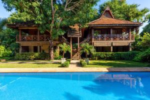 a house with a swimming pool in front of a house at La Palmeraie D'angkor in Siem Reap