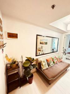 een woonkamer met een bank en een spiegel bij Azure Urban Resort and Residences by Precious Moments Staycation in Manilla