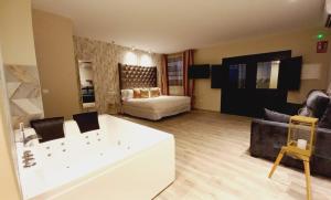 Airen Suites في تشينتشون: غرفة معيشة كبيرة مع حوض استحمام وأريكة