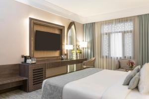 um quarto de hotel com uma cama e uma televisão de ecrã plano em دار الإيمان الحرم - Dar Aleiman Al Haram em Al Madinah