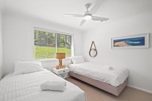 a bedroom with two beds and a window at Scenic 4-Bed Lake House 5-min Walk to Avoca Beach in Avoca Beach