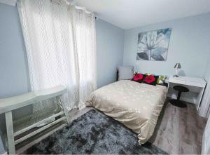 a bedroom with a bed and a desk and a window at Calgary Mountain Elegant Suite close LRT&UC& Free Parking in Calgary