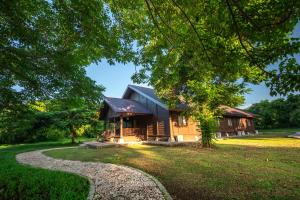 a log cabin with a gravel path in front of it at Samawa Seaside Resort in Sumbawa Besar