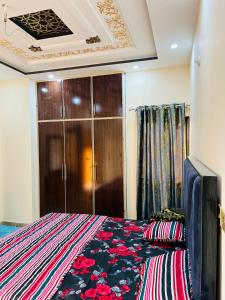 - une chambre avec un lit et une armoire en bois dans l'établissement Golden Plaza, à Gujrānwāla