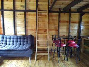 a living room with a couch and a table and chairs at CABAÑA MINCHY in Mazamitla +2 photos
