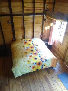 1 dormitorio con 1 cama en una habitación de madera en CABAÑA MINCHY, en Mazamitla