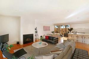 a living room with a couch and a fireplace at Sorrento Del Mar by Ready Set Stay in Sorrento