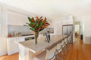 a kitchen with a long island with a vase of flowers at Sorrento Del Mar by Ready Set Stay in Sorrento