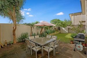 a patio with a table and chairs and an umbrella at Sorrento Del Mar by Ready Set Stay in Sorrento