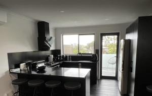a kitchen with a counter and stools in it at New Lynn Dream guest house in Auckland