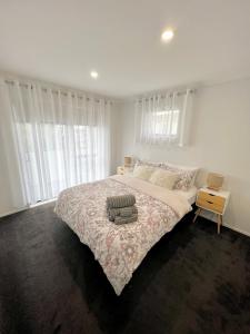 a white bedroom with a large bed and a window at New Lynn Dream guest house in Auckland