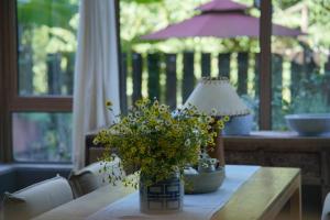 une table avec une lampe et un vase de fleurs sur elle dans l'établissement Ron Inn Xingping Hepan Xiaozhu, à Yangshuo