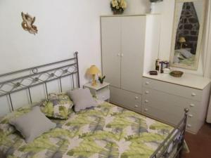 ein Schlafzimmer mit einem Bett mit einer Kommode und einem Spiegel in der Unterkunft Unabhaengige Wohnung in Calasetta mit Grill, Terrasse und Garten in Calasetta