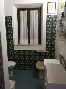 ein kleines Bad mit einem WC und einem Fenster in der Unterkunft Unabhaengige Wohnung in Calasetta mit Grill, Terrasse und Garten in Calasetta