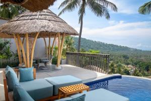 a villa with a swimming pool with a blue couch at Kalandara Resort Lombok in Senggigi