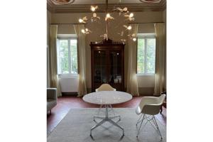 une salle à manger avec une table, des chaises et un lustre dans l'établissement Beautiful apartment in Tuscany, à Fauglia