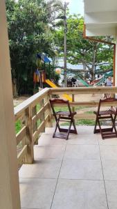 a wooden fence with two chairs and a playground at Refugio Bela Ilha via Barco in Florianópolis