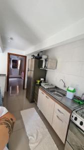 uma pequena cozinha com um lavatório e um frigorífico em Refugio Bela Ilha via Barco em Florianópolis