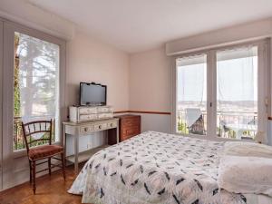 1 dormitorio con 1 cama, TV y ventanas en Appartement Ciboure, 4 pièces, 6 personnes - FR-1-4-687, en Ciboure