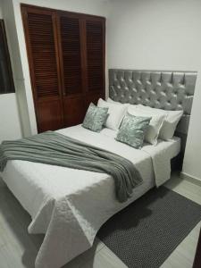 - une chambre avec un grand lit blanc et des oreillers dans l'établissement Apartamento céntrico en Cartagena, à Carthagène des Indes