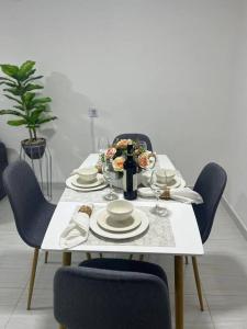 une table avec des chaises et une table blanche avec des assiettes et des verres à vin dans l'établissement Apartamento céntrico en Cartagena, à Carthagène des Indes