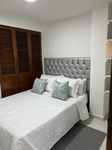 - une chambre avec un grand lit blanc et 2 oreillers dans l'établissement Apartamento céntrico en Cartagena, à Carthagène des Indes