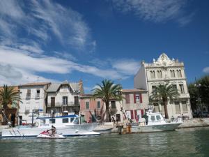 dos barcos están atracados en el agua junto a los edificios en Appartement Le Grau-du-Roi, 3 pièces, 4 personnes - FR-1-716-66 en Le Grau-du-Roi