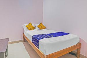 Una cama con almohadas amarillas y azules. en SPOT ON Sln Comforts Near Nagasandra Metro Station, en Bangalore