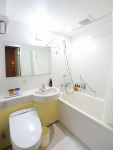 a bathroom with a toilet and a sink and a tub at Sunwest Hotel Sasebo in Sasebo