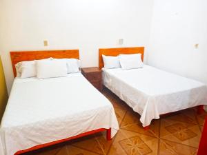 two beds sitting next to each other in a room at Hospedaje casa Yuca in Valladolid