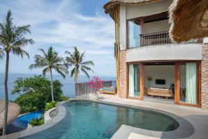 a villa with a swimming pool and the ocean at Kalandara Resort Lombok in Senggigi