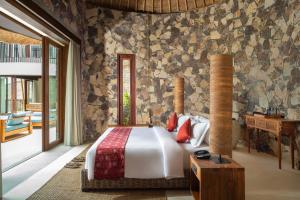 een slaapkamer met een bed in een kamer bij Kalandara Resort Lombok in Senggigi 