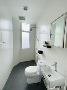 a white bathroom with a toilet and a sink at Halo Rooms Hotel in Wakaf Baharu