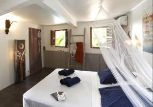 - une chambre avec un lit blanc et une moustiquaire dans l'établissement Villa Vue Marine, au Diamant