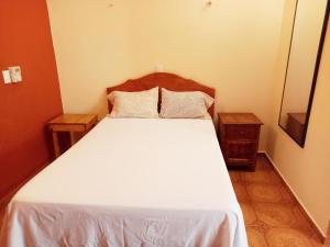 a bedroom with a white bed with two night stands at Hospedaje casa Yuca in Valladolid +79 photos